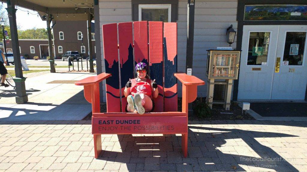 Theresa taking a break from riding her bike and sitting in a giant chair.