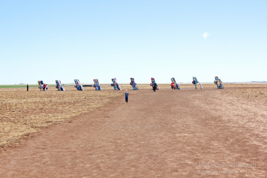 Child running towards Cadillac Ranch