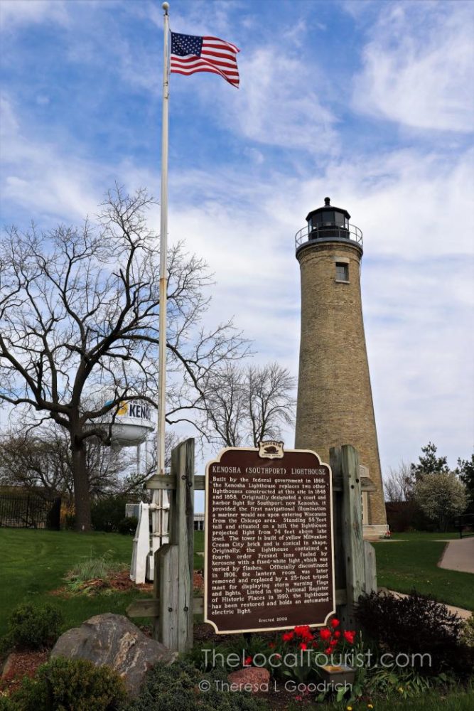 Southport Lighthouse with the Kenosha water tower in the background and an American flag