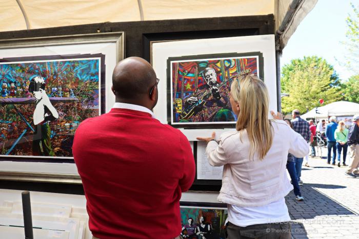 Artist showing her work with a visitor at the Ridgeland Fine Arts Festival