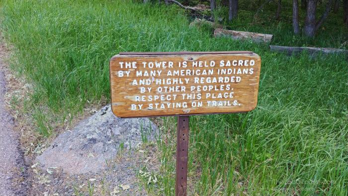 Sign informing visitors to respect the sacred land and stay on the trail