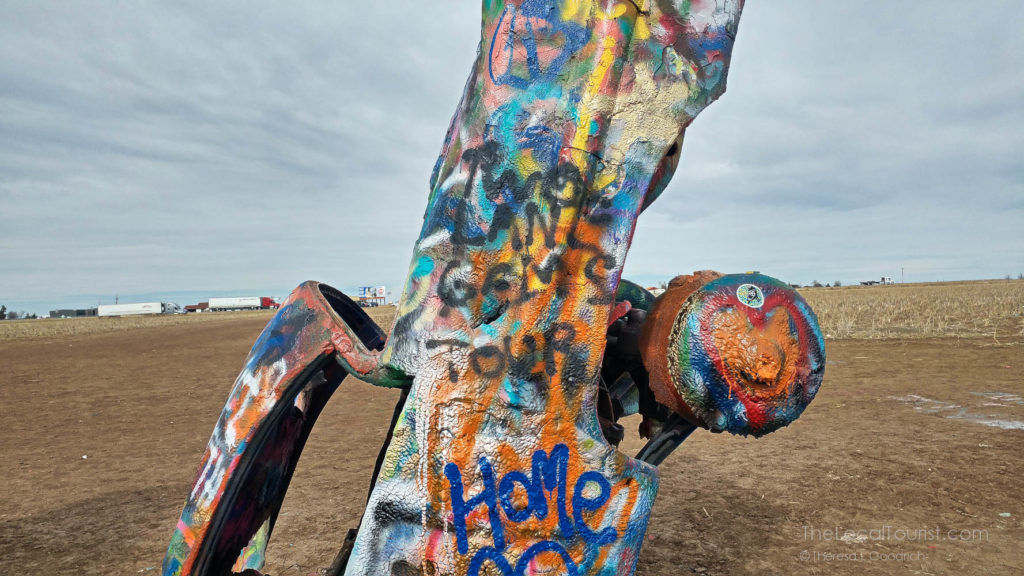 Buried Cadillac painted with Home in blue on the door