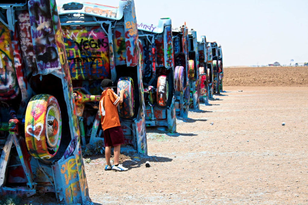 Bay painting on the tire of a Cadillac buried outside of Amarillo on Route 66