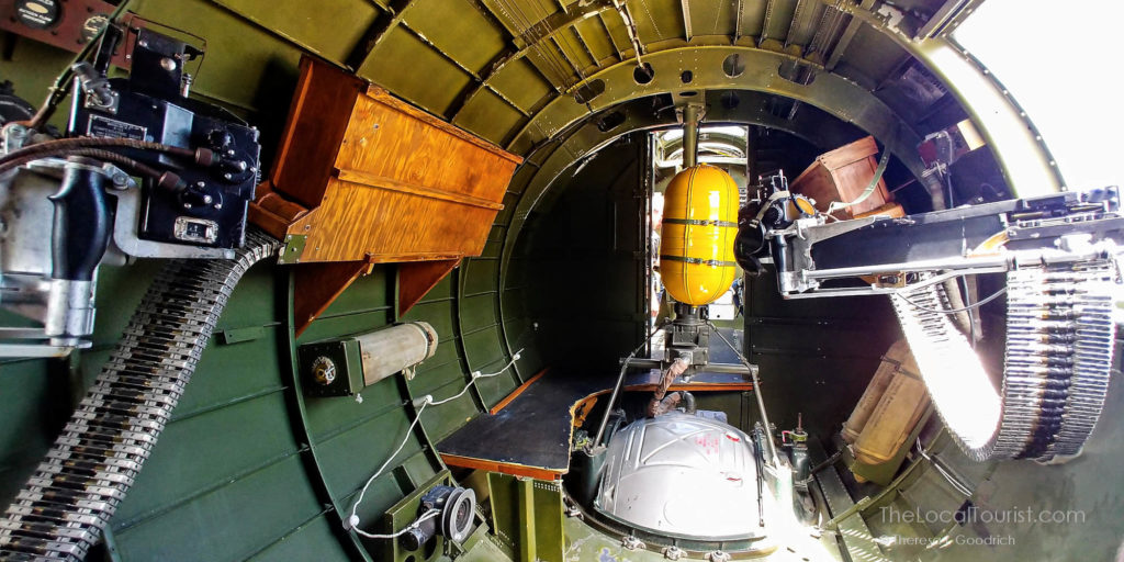 Looking towards the cockpit of Aluminum Overcast from the rear of the plane. Machine guns on either side and a yellow oxygen tank.