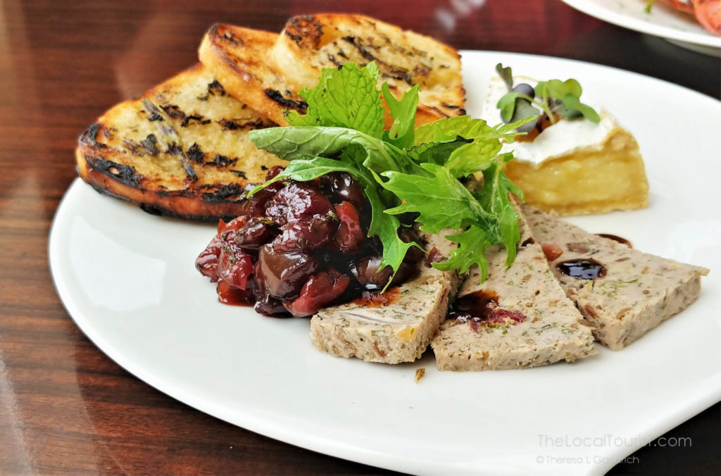 country pate with a cherry compote port sauce, warm camembert, crostini with rosemary butter, garnished with microgreens and a cucumber relish